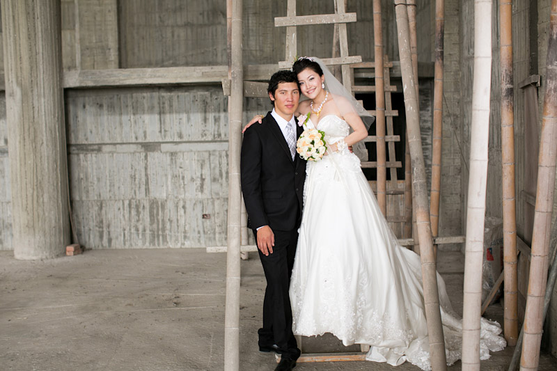 Taiwan wedding. Bride and groom on a ladder in unfinished temple. 
