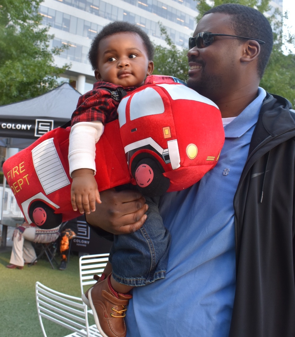  Baby’s first Halloween comes a day early | Honeycomb Moms | My husband, Donzell Floyd, proudly holds our son, Donovan, at Midtown Atlanta’s Scare on the Square Tuesday. LAUREN FLOYD / INFO@HONEYCOMBMOMS.COM 