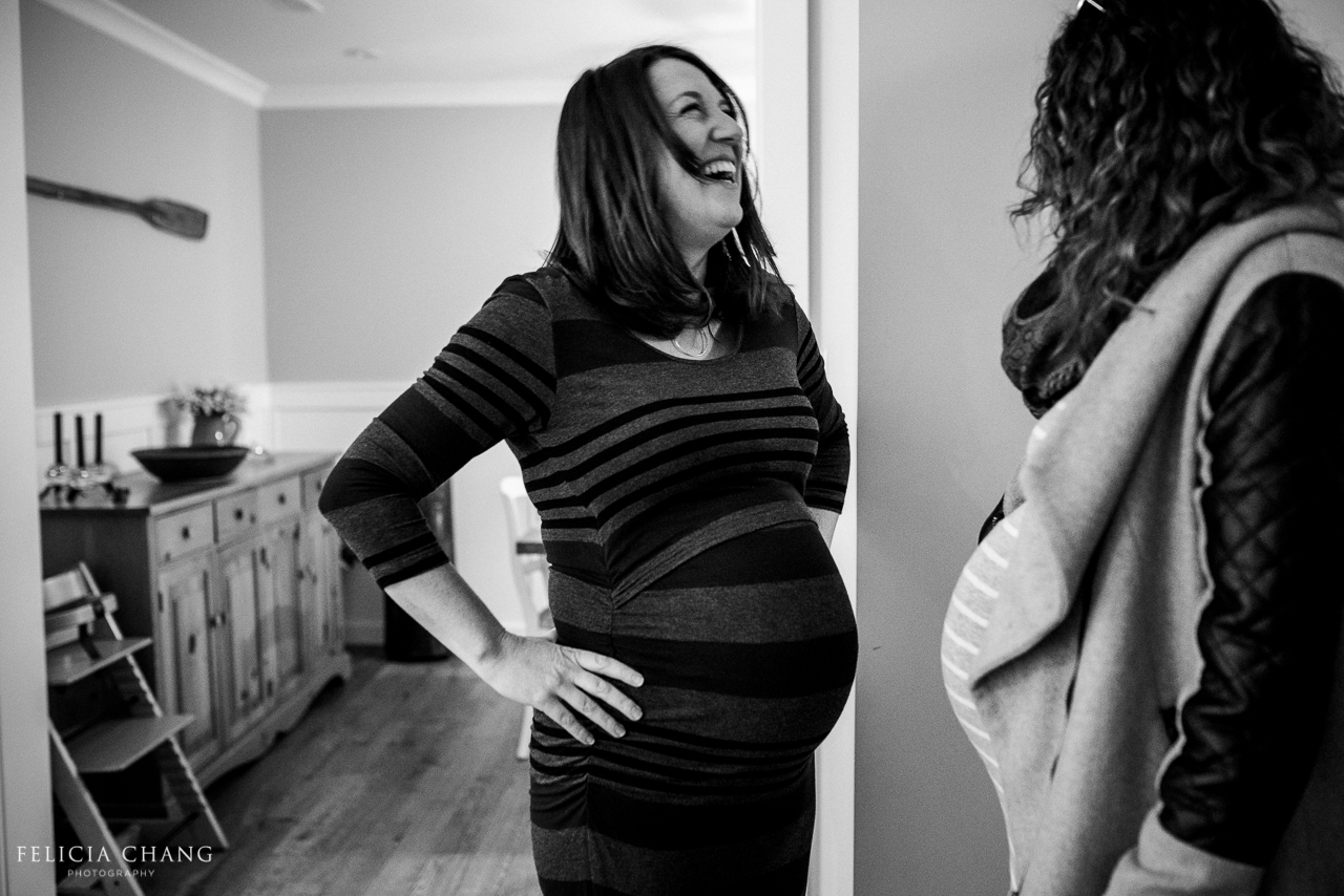 two pregnant moms laughing together