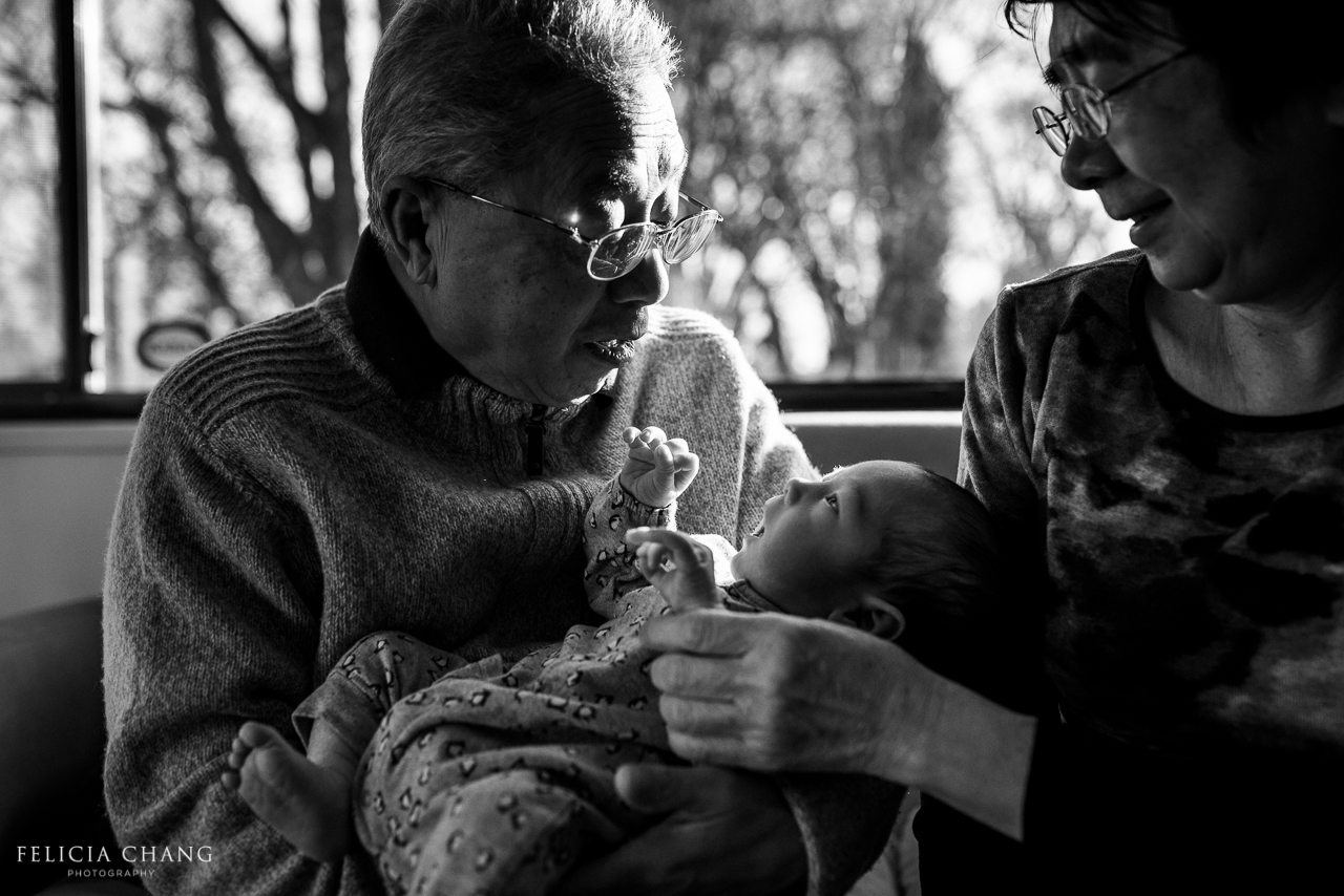 Grandparents cuddling with newborn grandson