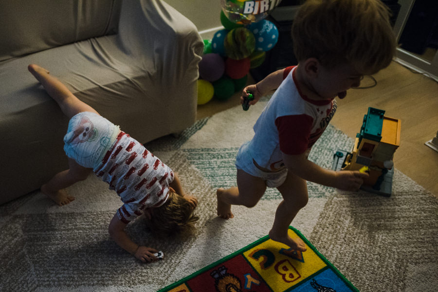 twin boys jumping around in their family room