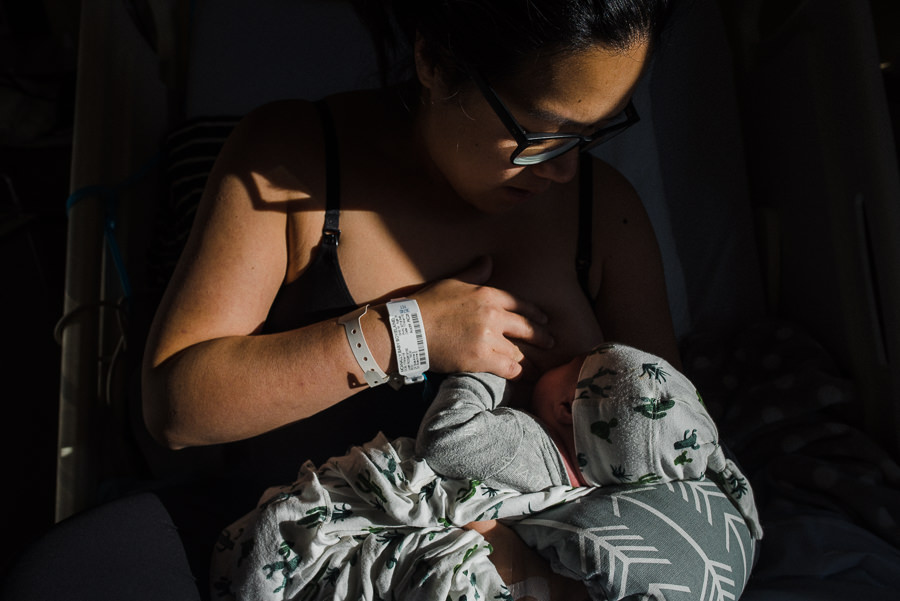 mom nursing her newborn baby boy on hospital bed