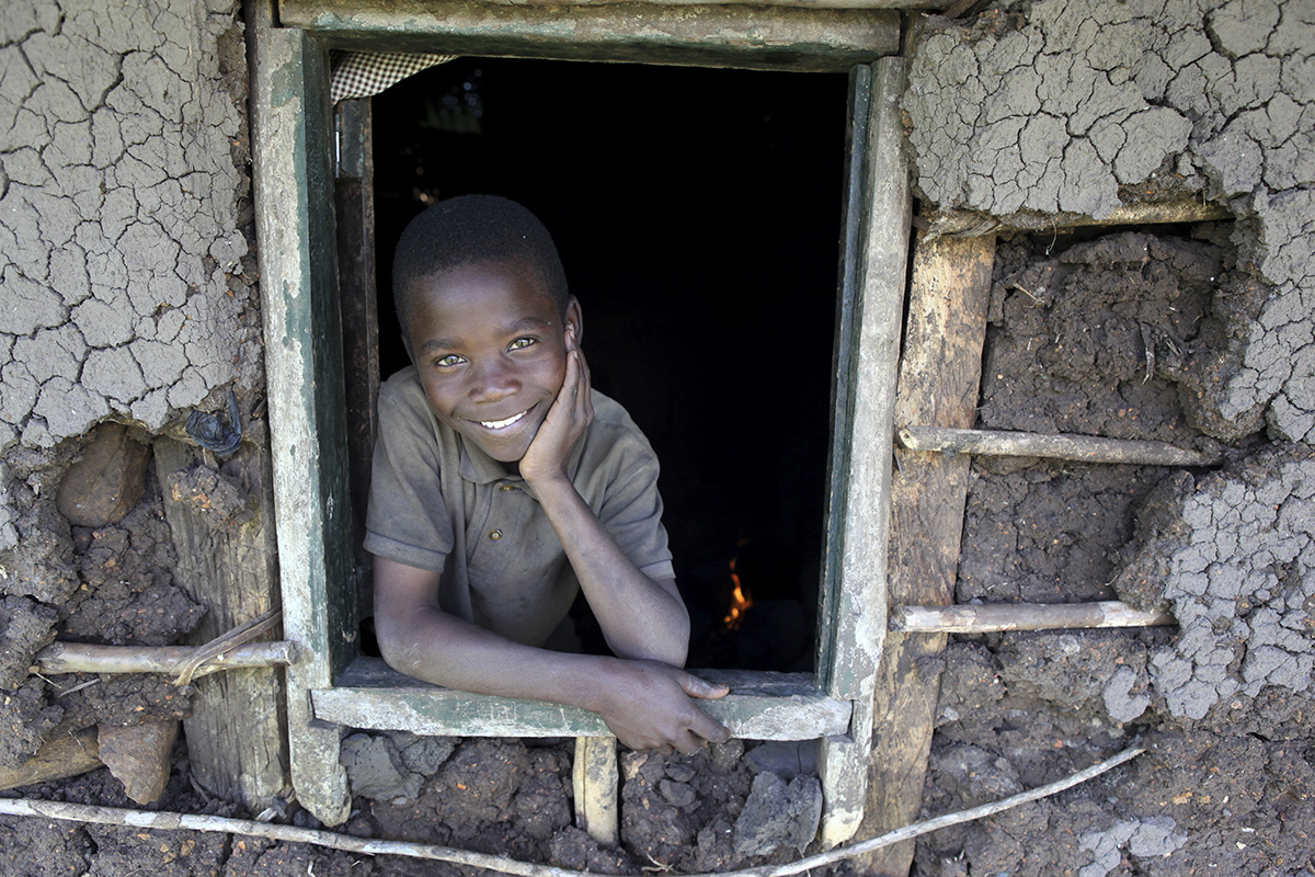 Victor Owino, 9, stares out the window of the home he shares with his four older brothers in Homa Bay, Kenya. Photographing at either eye level or slightly below gives a sense that the person in an image is someone to look up to and admire. Photo courtesy of Sara A. Fajardo/Catholic Relief Services