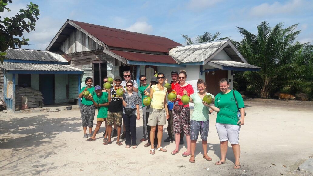 2016 Volunteers pose for a photograph, coconuts in hand.