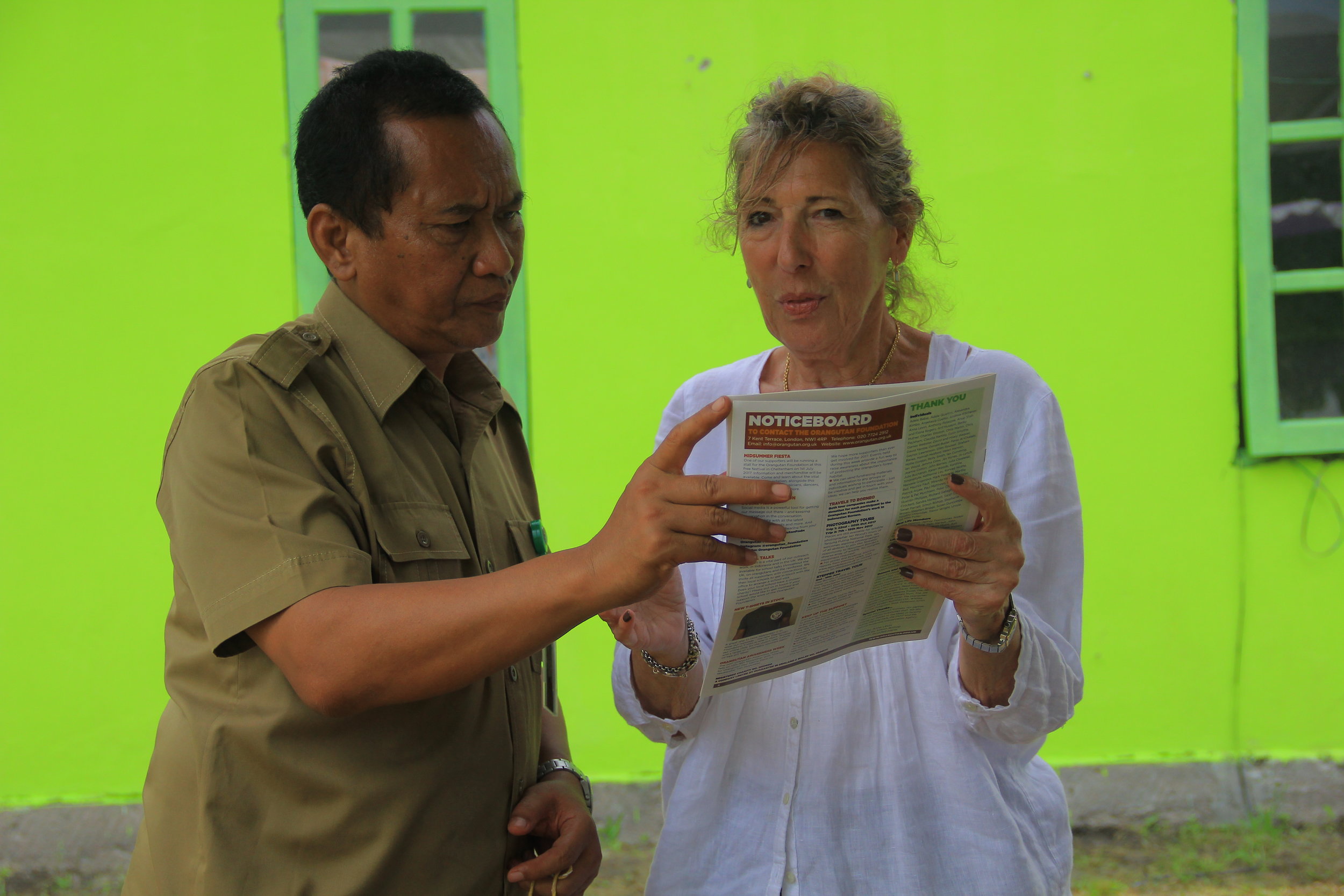 OF Director Ashley Leiman OBE and Pak Adib reading our latest issue of Red Ape. Image© Orangutan Foundation.