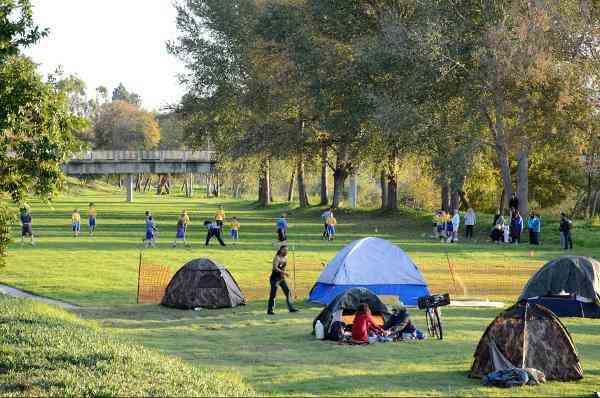 tents in a park with soccor players
