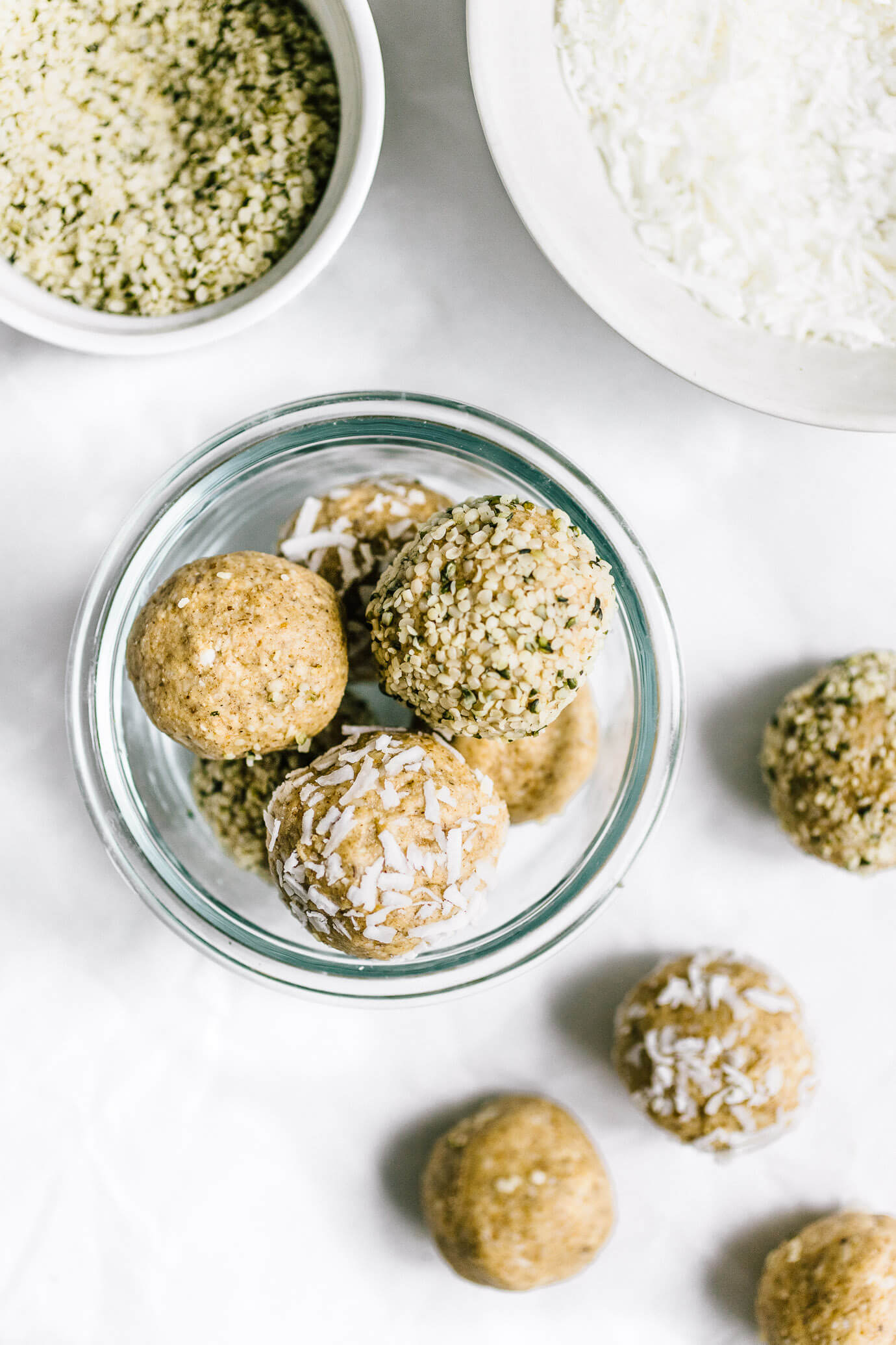 cashew coconut collagen bites in glass jar with hemp seeds and coconut flakes