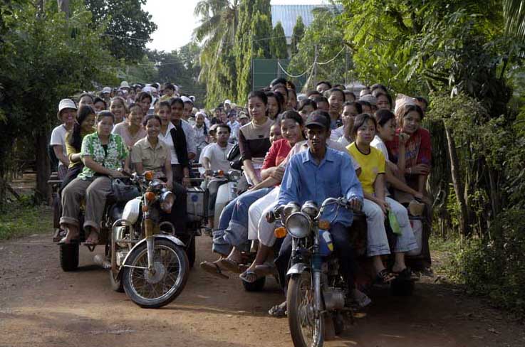 Garment workers going home on motorcycle remorques in Cambodia. Source: Wikimedia Commons