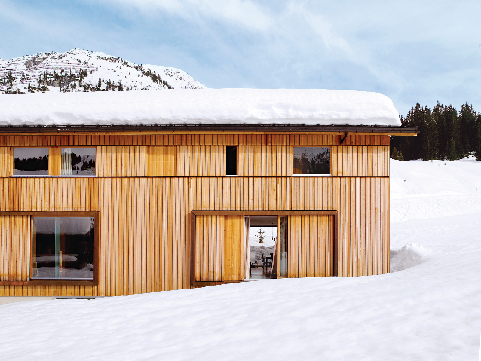 The house, which is gently pushed into the hillside, has a large basement holding a garage, ski room, storage areas, and utility spaces as well as the entrance hall.