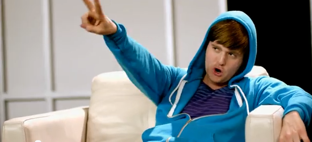 A screencap from the video for Hollywood, with Michael Buble dressed ridiculously as Justin Bieber with a Bieber wig and a bright blue hoodie.