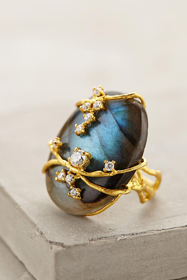 A blue labradorite cabochon is wrapped with gold vines. Small white diamonds glitter here and there on the vines.