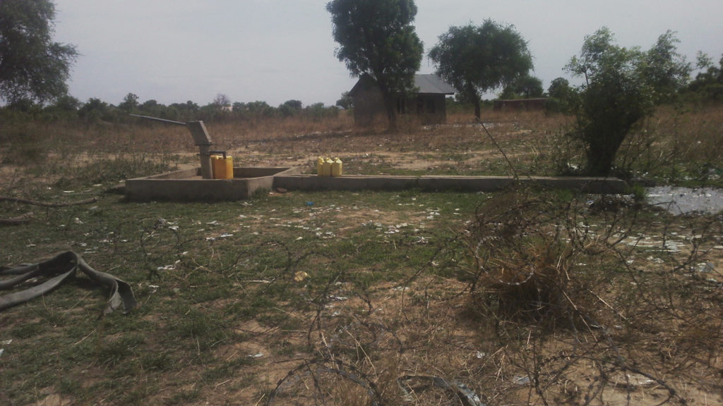 The water well on ASC land in Bor, Jonglei State, South Sudan. Abandoned building in background.