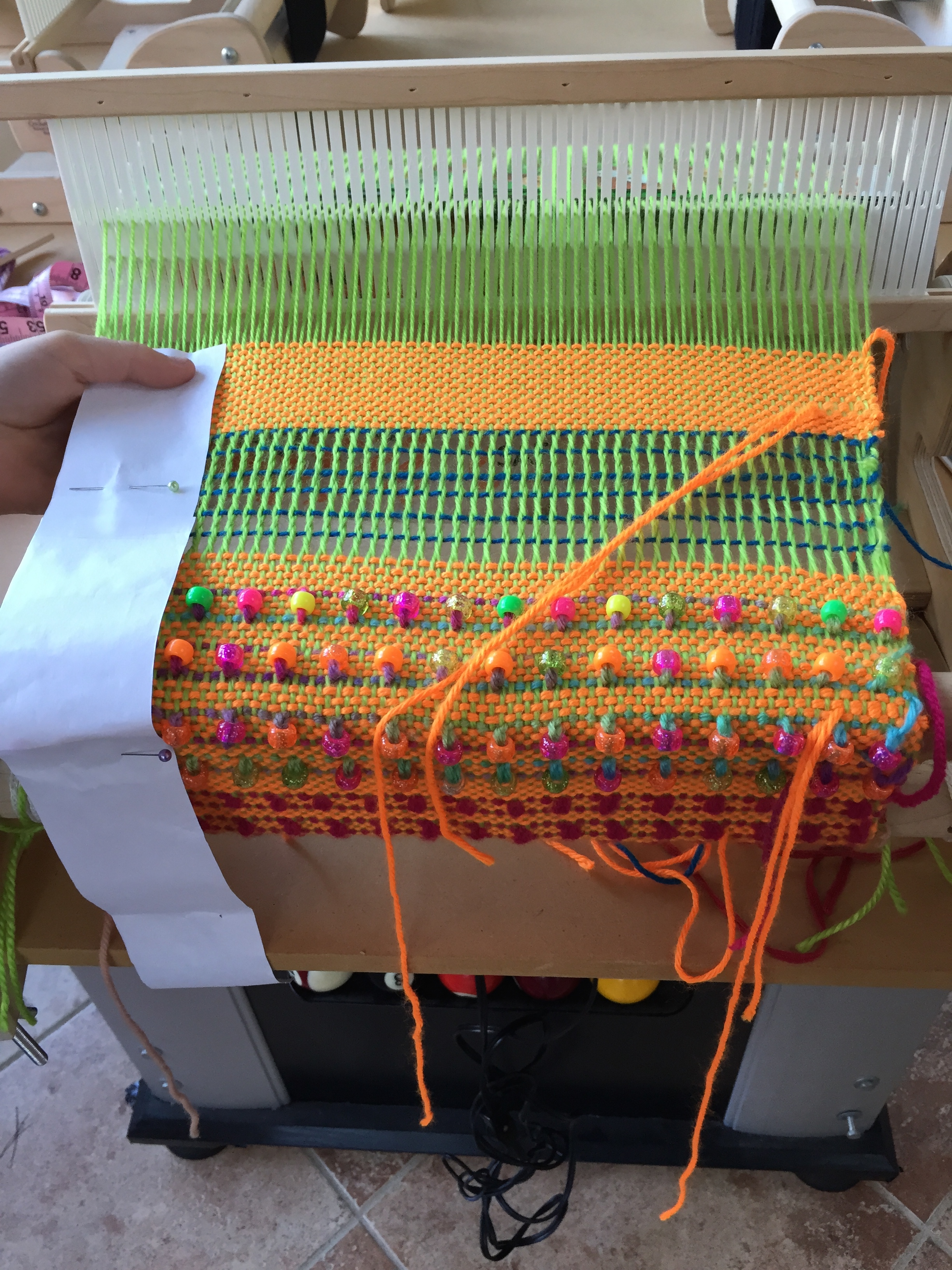 Finishing the weaving on part of a tote bag.