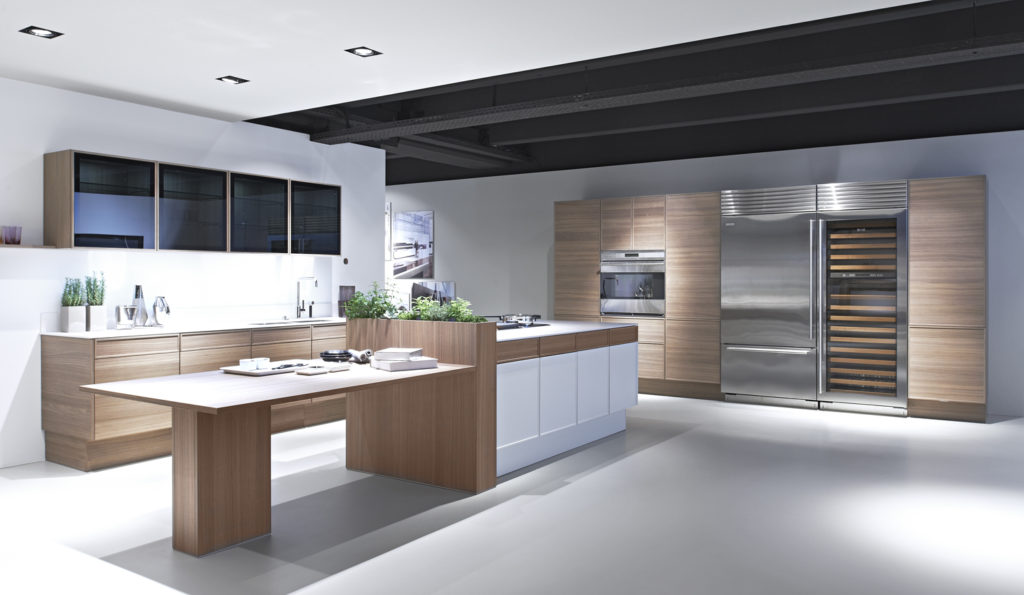 The new +EDITION collection from Poggenpohl combines the best of both worlds, crisp clean white lacquer with warm natural walnut wood veneer.  It is available in flat panel or thin frame detail door styles. New black glass upper wall cabinets include the same thin frame details with finished interiors and LED lighting.