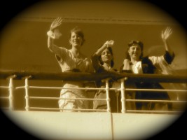 Eva waves from the railing with two fellow "passengers" on the Queen Mary.