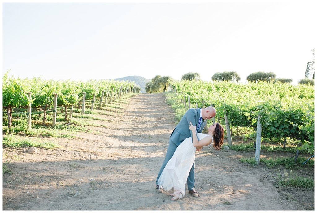 groom dipping in the vineyard