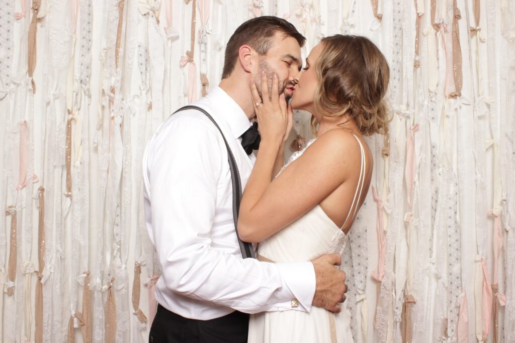 A bride and groom in a photo booth at their calgary wedding reception
