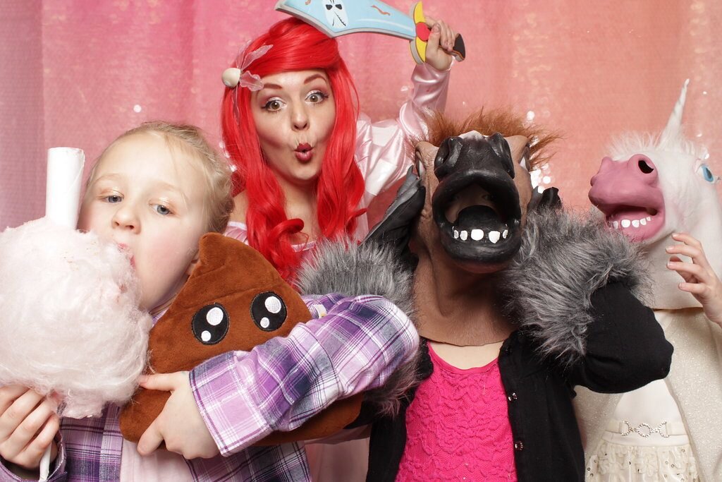 Ariel and some kiddos take some photos in a photo booth