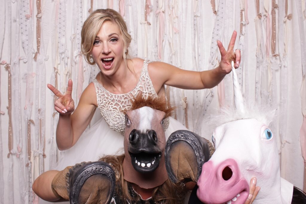 A bride and her friends in a a photo booth at her wedding reception