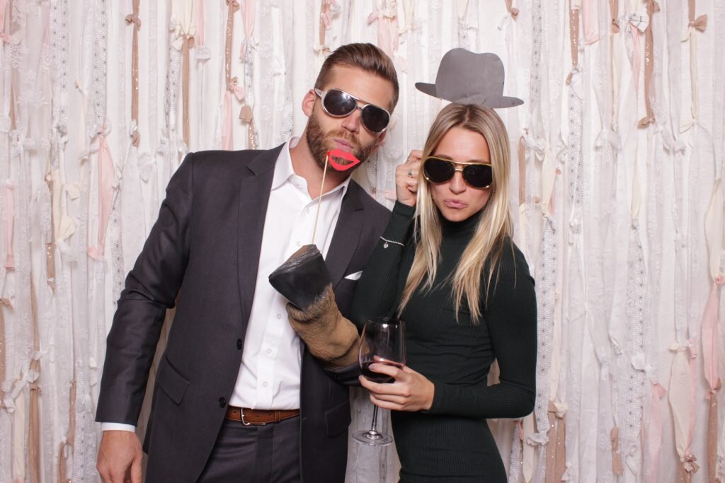 wedding guests get silly with a few props in a wedding photo booth rental in canmore