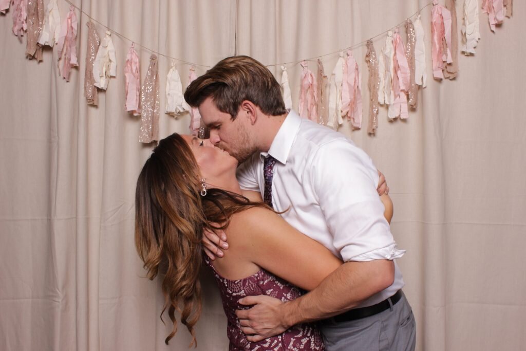 A couple steals a kiss in a calgary wedding photo booth rental
