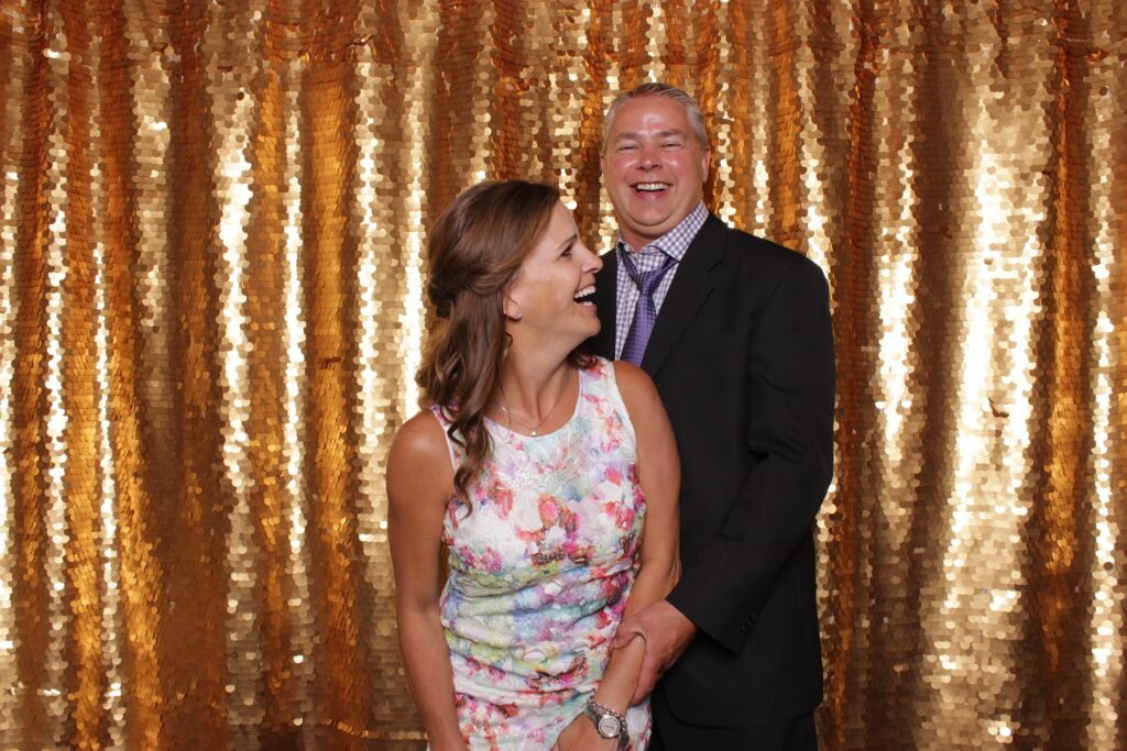 a couple poses for a photo in a wedding photo booth rental