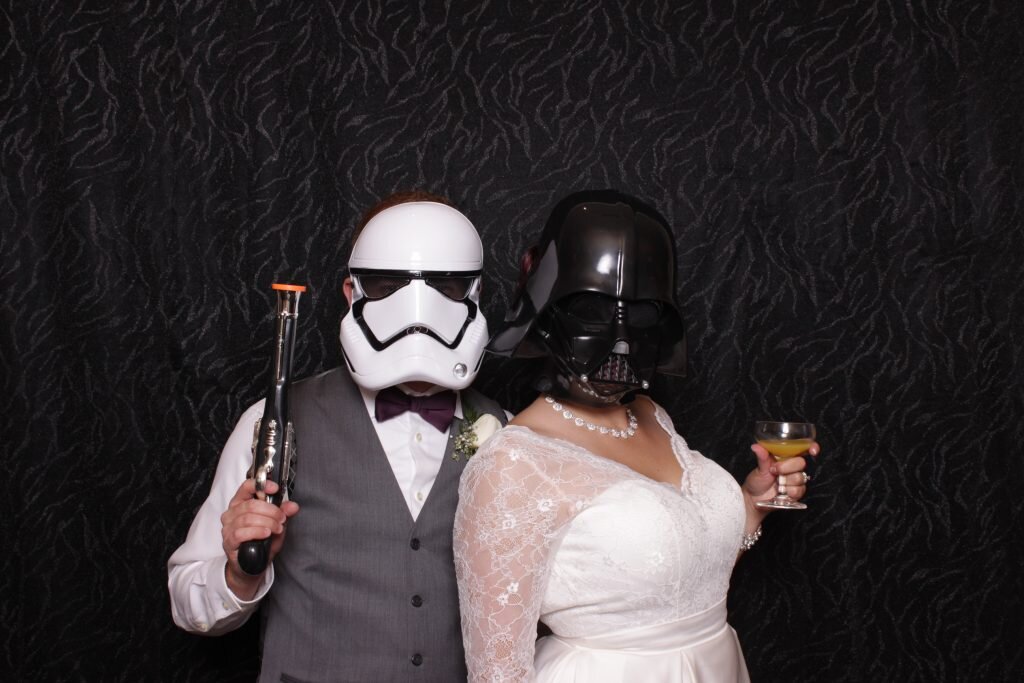 a bride and groom pose in star wars props at a Calgary wedding photo booth