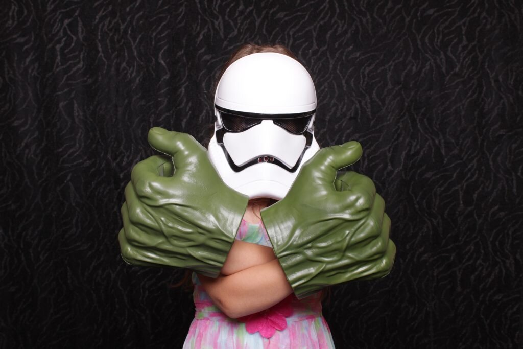 a kid posing in a calgary photo booth with star wars props on