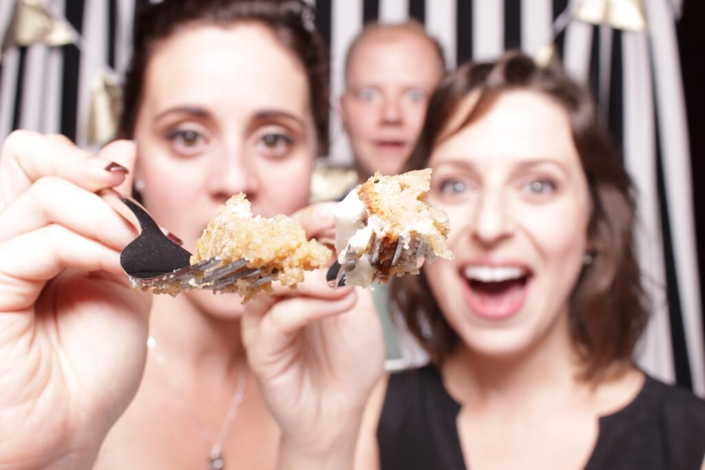 a photo booth blooper as guests feed the booth some wedding cake