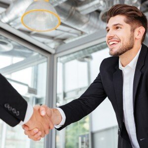 Two successful businessmen shaking hands on business meeting in office