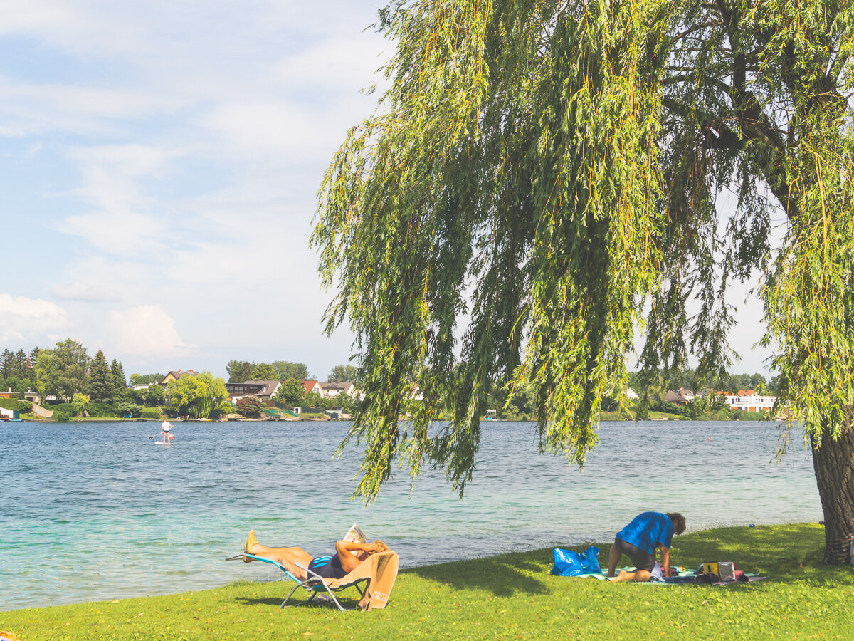 Woman sunbathes beside a lake