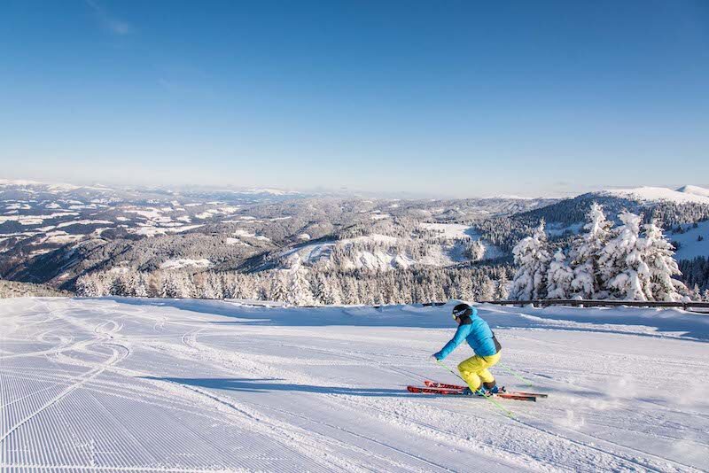 image of person skiing down alpine panorama view