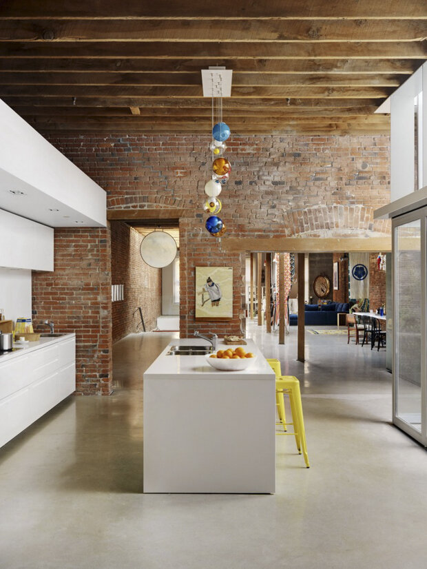 clean white kitchen with wood beams and a brick wall. perfection.
