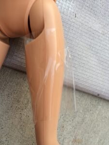 Taping off Barbie's Legs to make modest Barbies