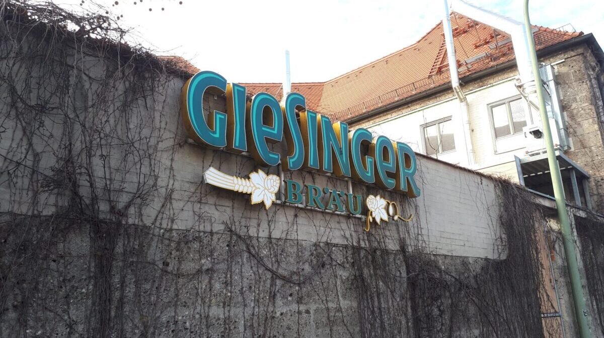 The concrete front of Giesinger Bräustüberl with a big sign promoting the bar
