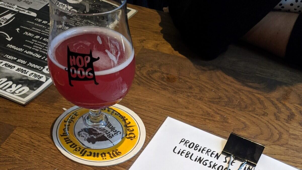A picture of a sour lambic beer on the table amongst some menus at Hop Dog in Munich