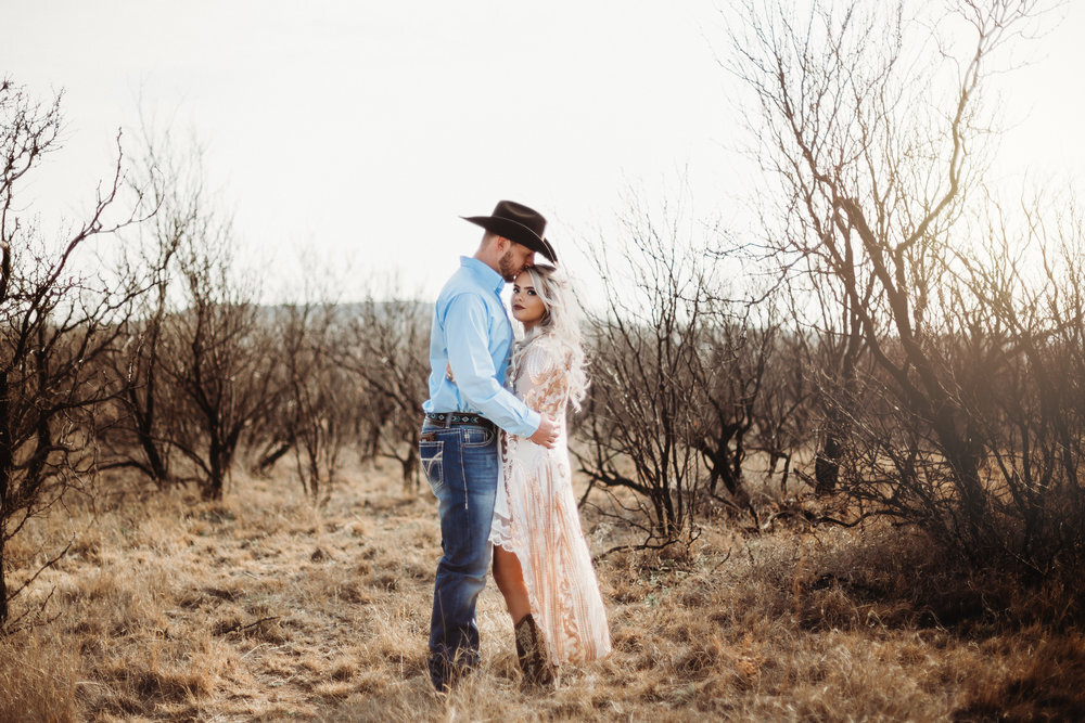  Engaged couple with kiss on the forehead cowboy hat sequins and cowboy boots with neutral background #engagementphotos #engaged #personality #amarillotexas #engagementphotographer #lifestylephotos #amarillophotographer #locationchoice #texasengagementphotos #engagment #tealawardphotography #westernstyle 
