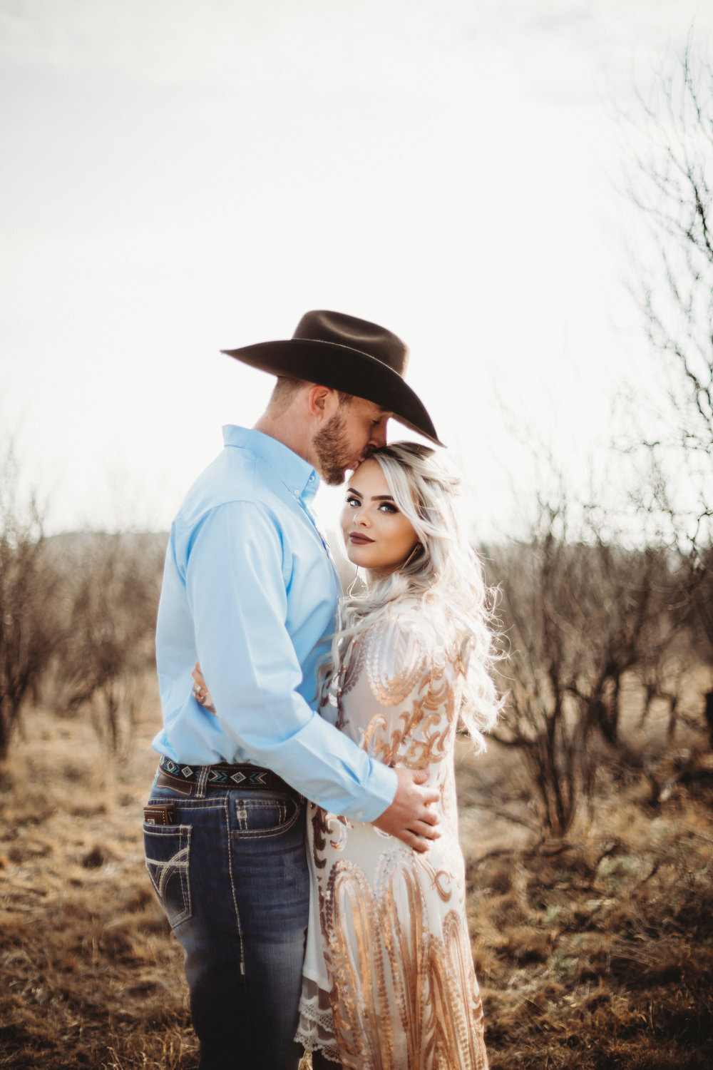  Close up of engaged couple with neutral background and kiss on the forehead #engagementphotos #engaged #personality #amarillotexas #engagementphotographer #lifestylephotos #amarillophotographer #locationchoice #texasengagementphotos #engagment #tealawardphotography #westernstyle 