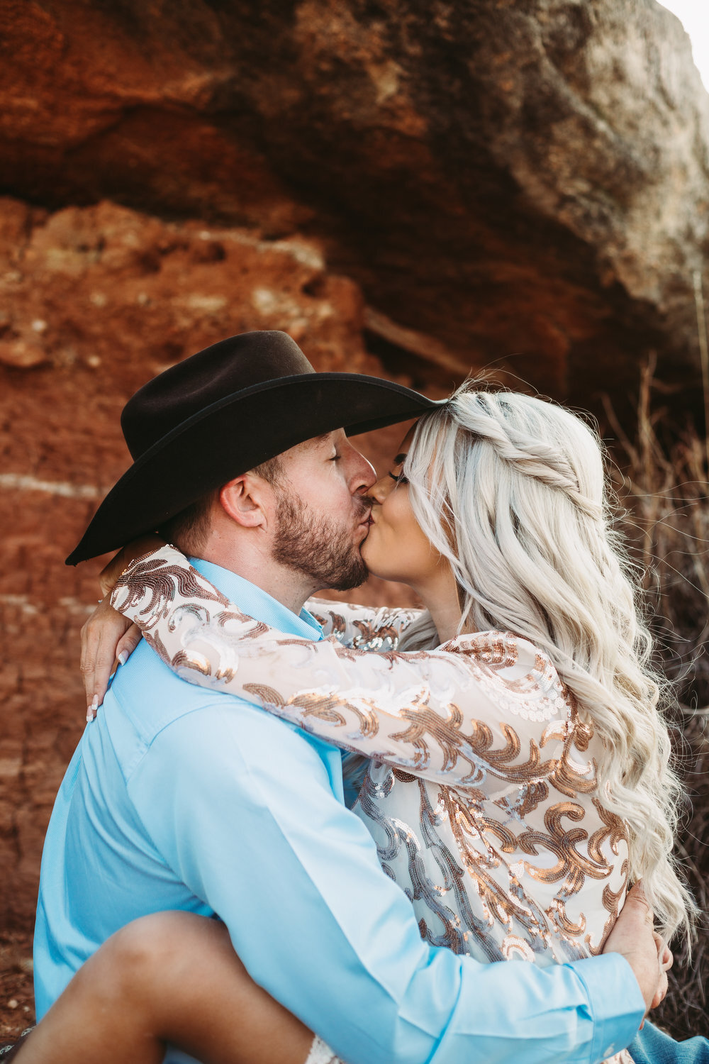  Groom to be carrying his future bride with accents on her sequin dress and black cowboy hat with red rock in the background #engagementphotos #engaged #personality #amarillotexas #engagementphotographer #lifestylephotos #amarillophotographer #locationchoice #texasengagementphotos #engagment #tealawardphotography #westernstyle 
