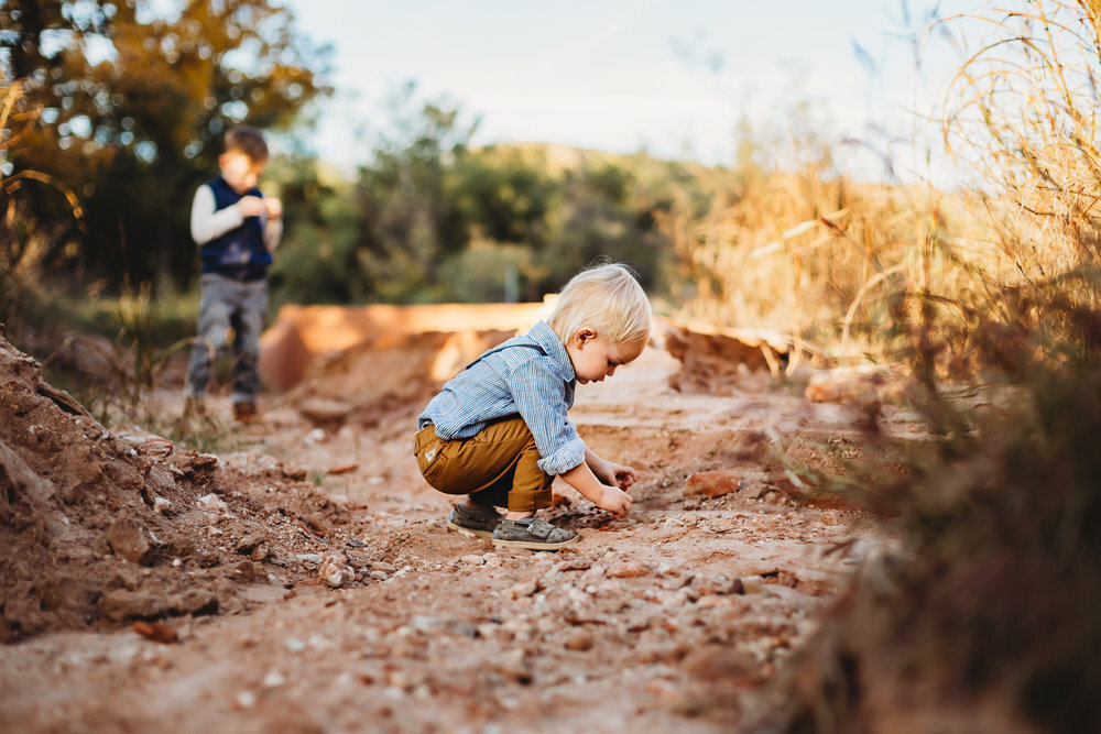  Focus on boy playing with rocks and brother in the background #tealawardphotography #texaslocationchoice #amarillophotographer #amarillofamilyphotographer #emotionalphotography #engagementphotography #couplesphotography #pickingaphotosessionlocation #whatsimportant #everythingtogether #pickingcolorsforphotos #location #photosessionlocation 