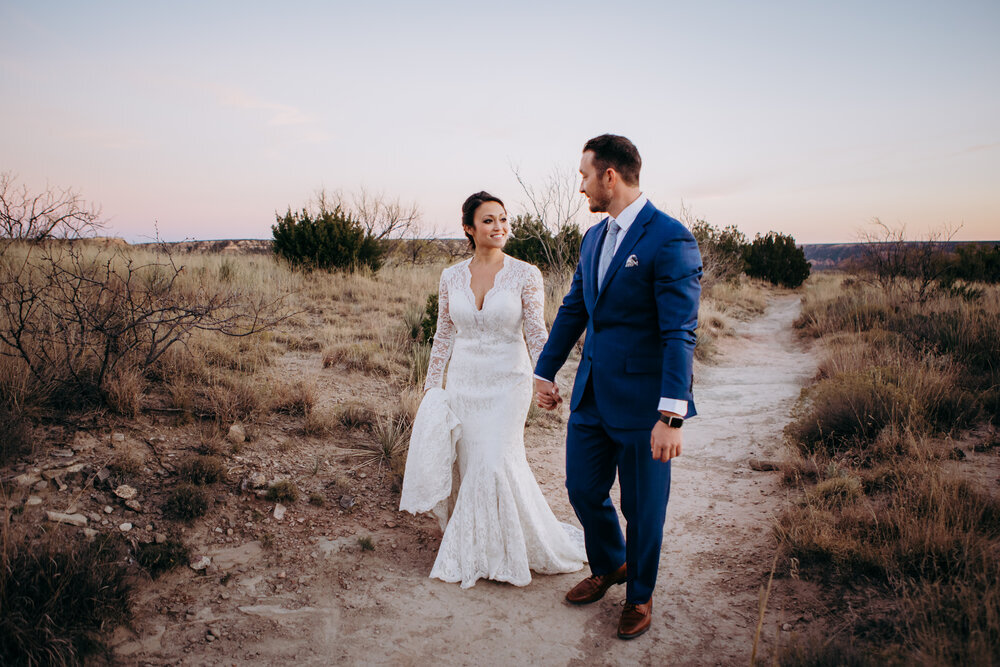  The bride and groom walk hand in hand with each other down the pathway in Palo Duro Canyon #tealawardphotography #texasweddings #amarillophotographer #amarilloweddingphotographer #emotionalphotography #intimateweddingphotography #weddingday #weddingphotos #texasphotographer #inspiredwedding #intimatewedding #weddingformals #bigday #portraits 