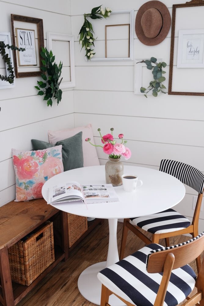 Small breakfast nook with tulip table and bench, black, white, and wood tones with a dash of pink for Spring! 