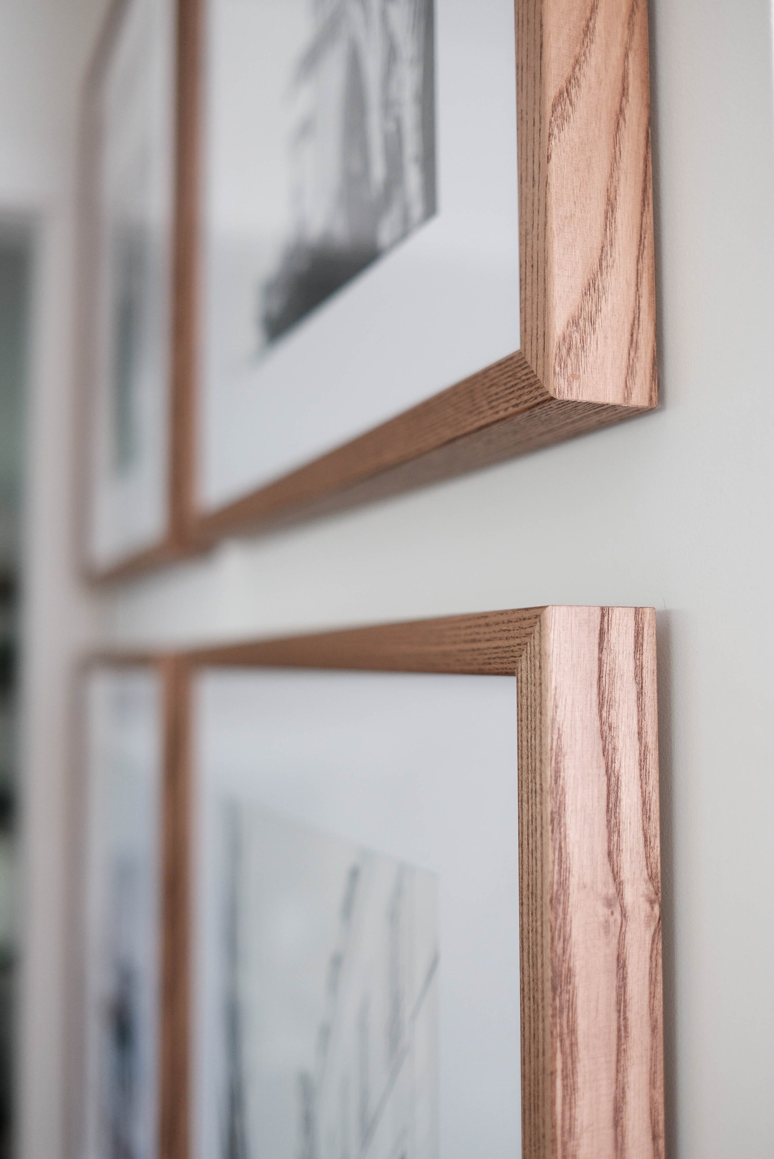 Close-up of symmetrical gallery wall in a hallway with light walnut frames from PosterJack. 