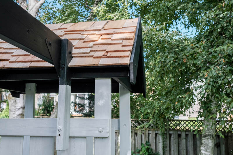Black and white kids treehouse with cedar shaker roof