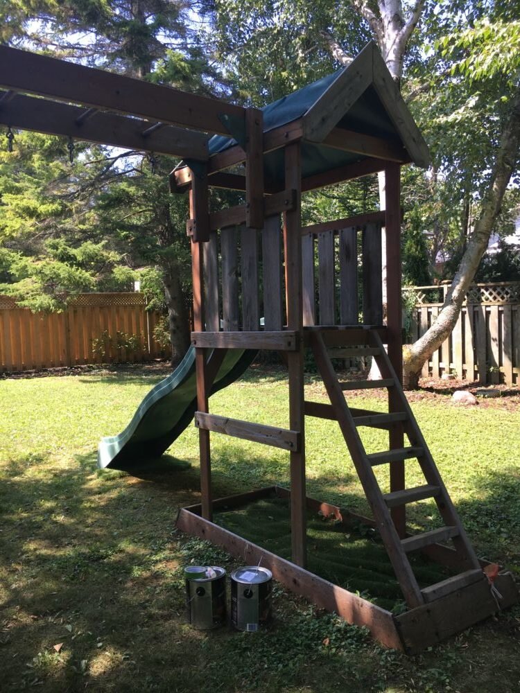 Kids playset in shaded backyard, detail of the ladder and slide