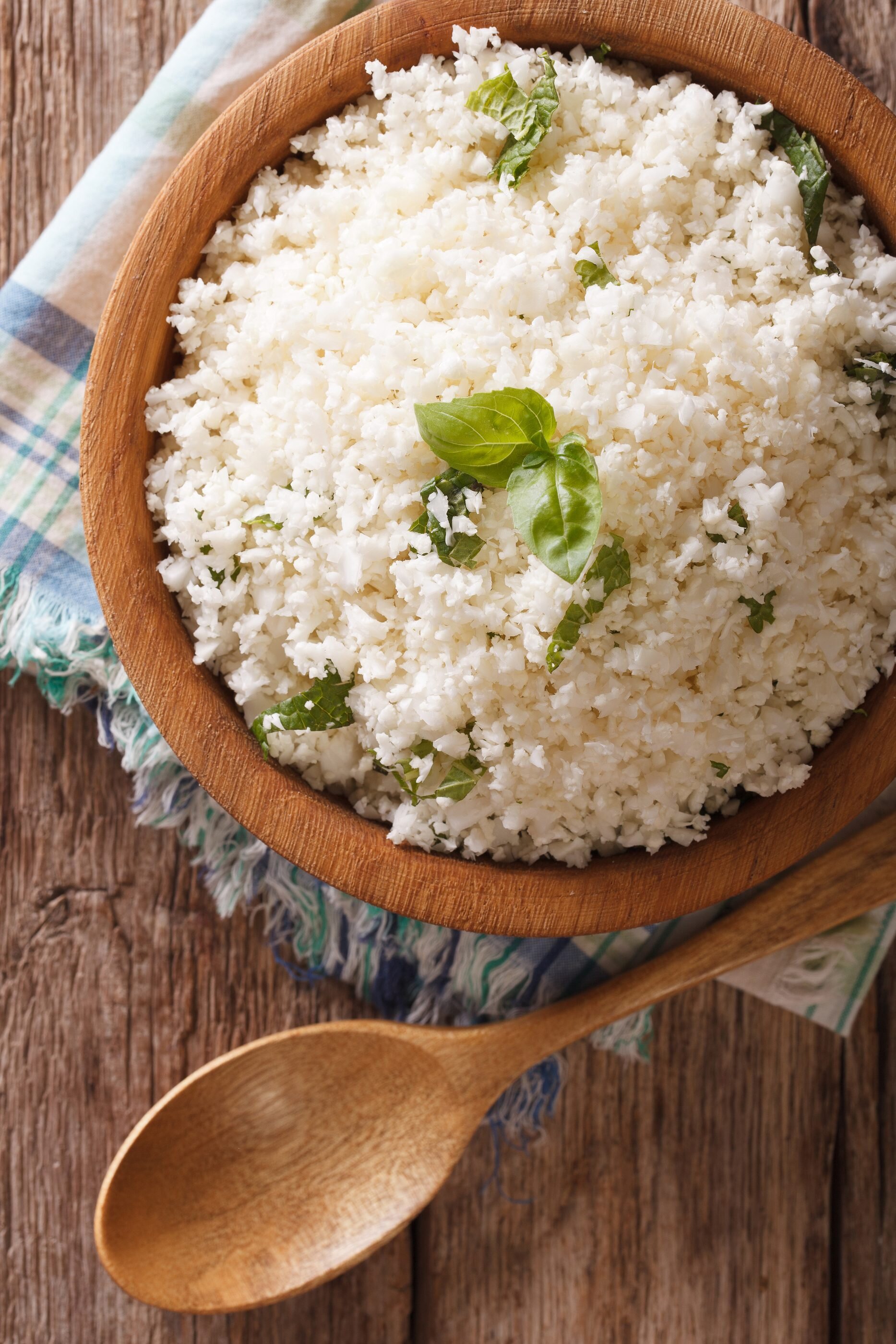 Paleo Food: Cauliflower rice with herbs close-up in the bowl. Vertical top view