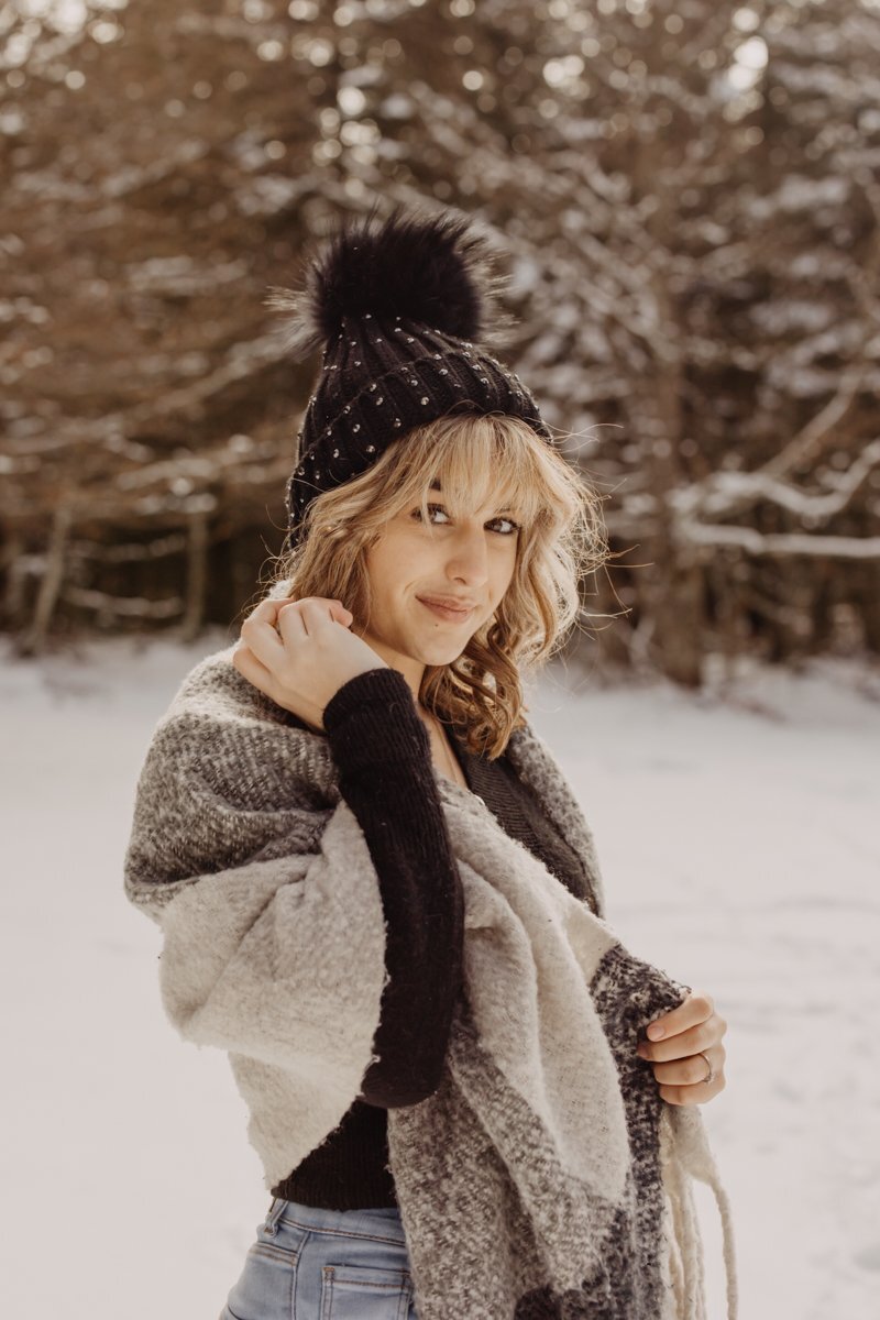 portrait d'une jeune femme avec une bonnet dans la neige