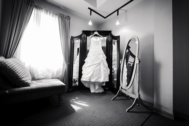 Wedding gown hanging on a mirror.