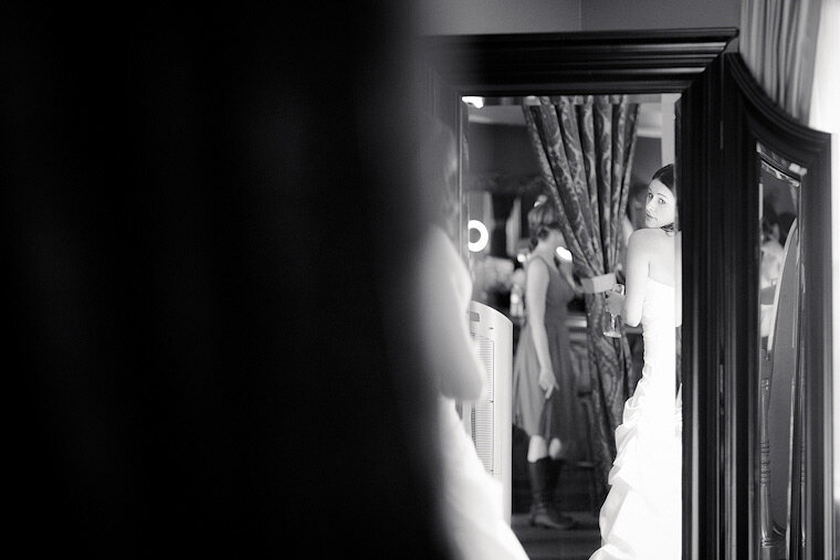 Bride looks at her reflection in the mirror.