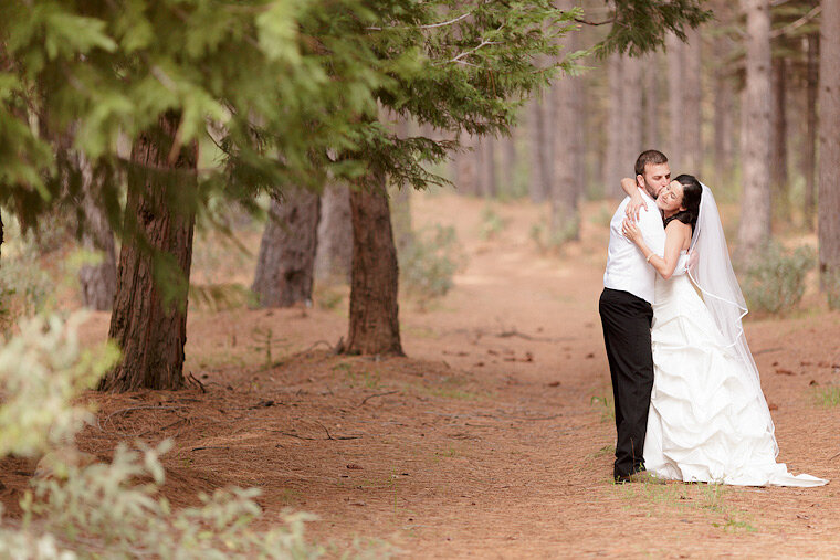 Bride and groom walk together in the forest.